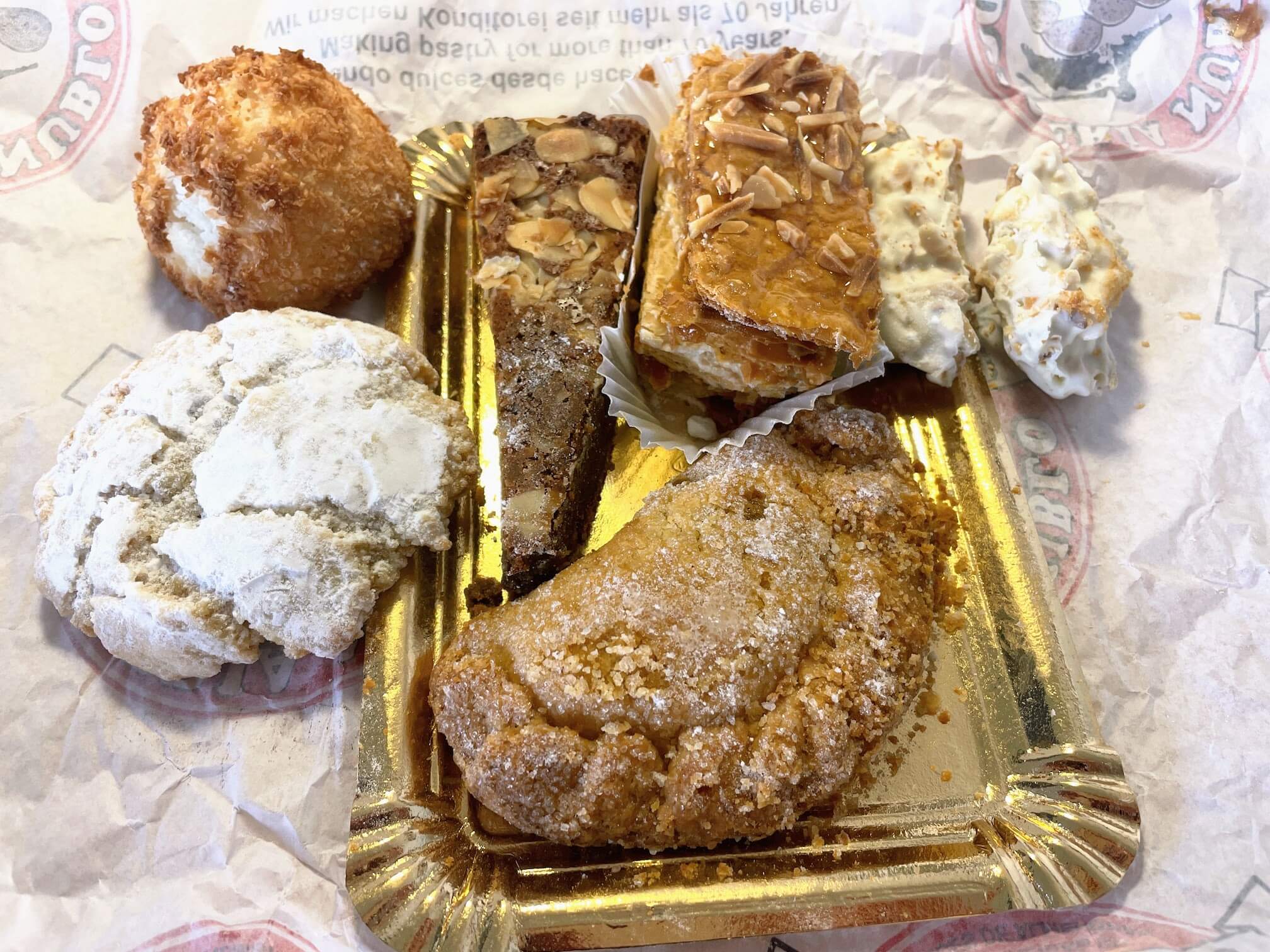 Пирожные все оказались вкусные. Но наверное самое вкусное было беленькое круглое слева, нежное из миндальной муки. Пирожное в виде полукруга с вкусной начинкой похожей на яблочное повидло. Слева сверху кокосовое пирожное, а треугольничек - шоколадно-миндальное, похожее на картошку.