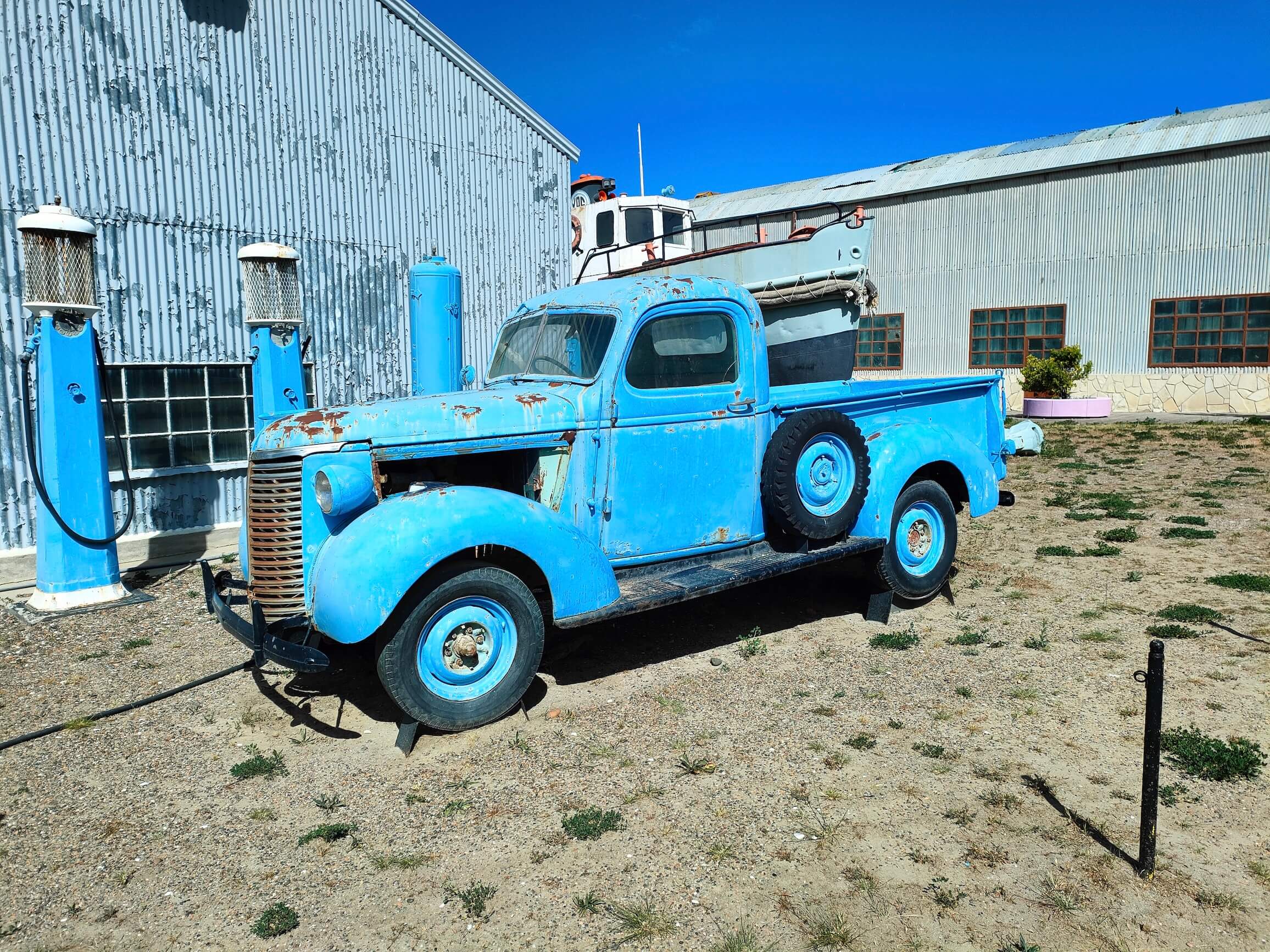 An old Chevrolet and gas pumps